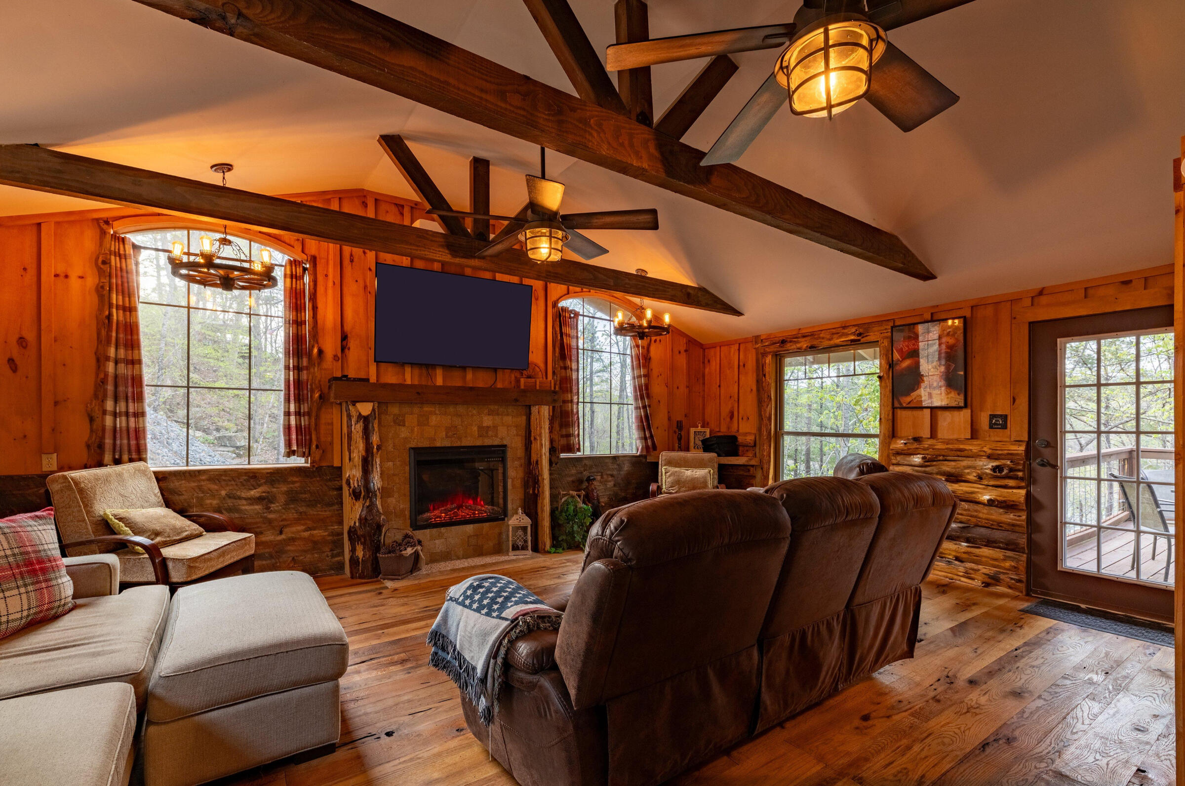 Cozy Cabin Comfort Rustic wood beams, warm lighting, and an electric fireplace make this living room the perfect place to unwind after a day on the lake.