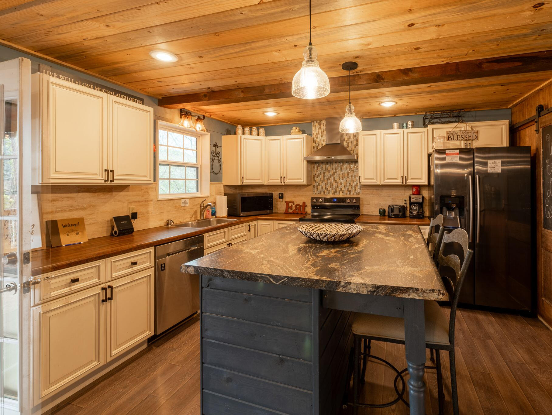 Fully Stocked, Ready to Cook This spacious kitchen features a large island, modern appliances, and everything you need to cook, snack, or pour a drink with friends.